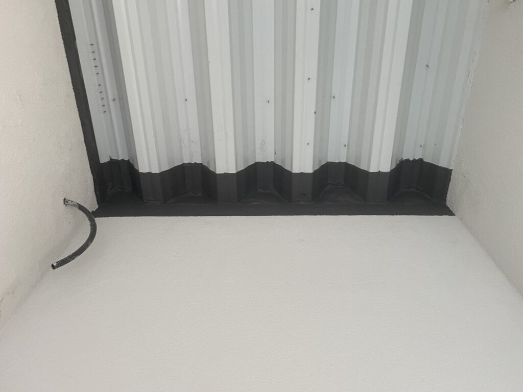 Zabezpieczenie dylatacji na styku ściany z blachą trapezową za pomocą masy Promaseal A-spray